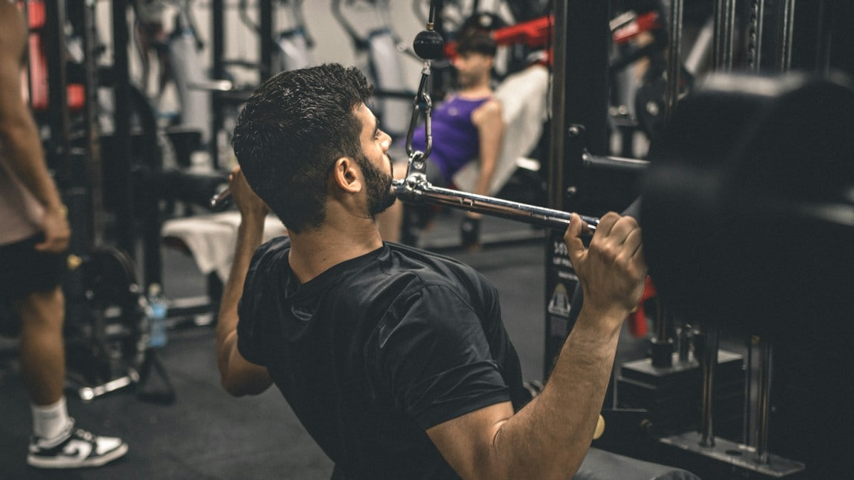 a man in a gym lifting a bar